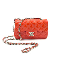 Coral quilted handbag with chain strap on a white background