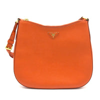 Orange handbag with gold accents on a white background