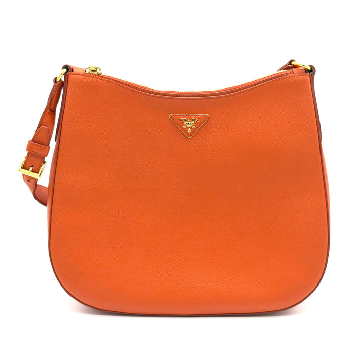 Orange handbag with gold accents on a white background