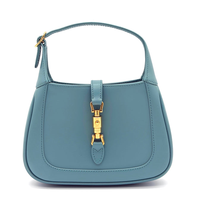 Blue handbag with gold hardware on a white background