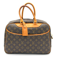Louis Vuitton monogram handbag with brown leather handles on a white background