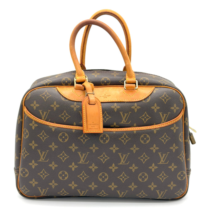 Louis Vuitton monogram handbag with brown leather handles on a white background