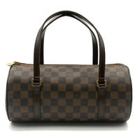 Brown checkered handbag with black handles on a white background